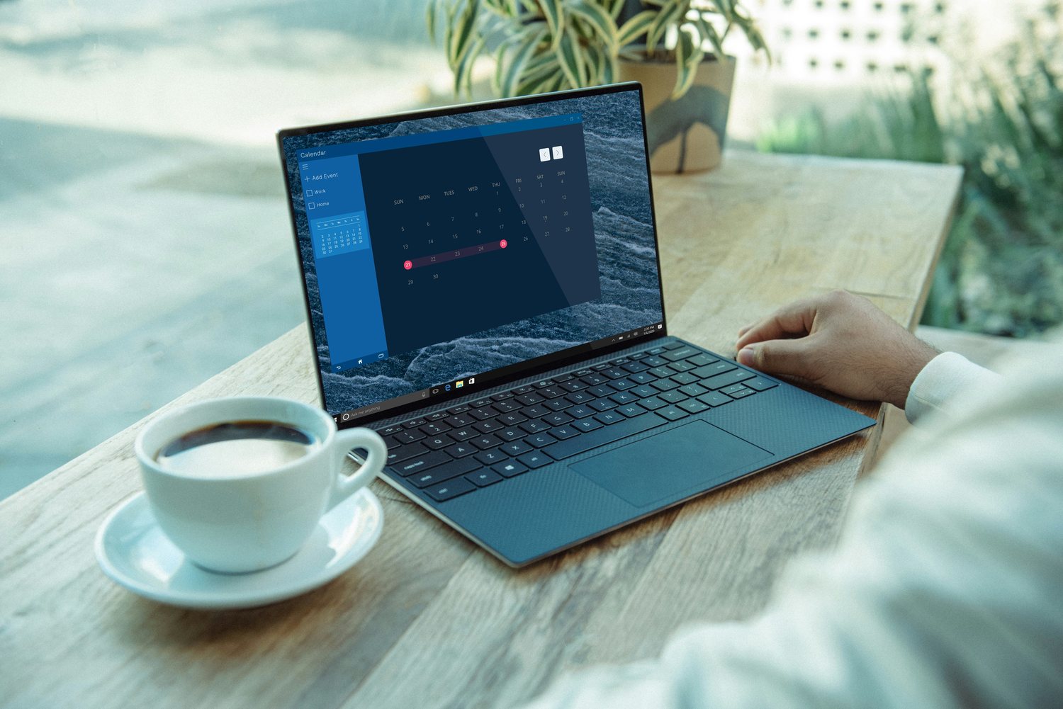 A hand resting on a laptop trackpad with a dated schedule open on the screen