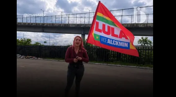 Com bandeira de Lula nas mãos, mulher surpreende e pede voto em Flávio Bolsonaro