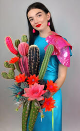 Kennedy Montano in a colorful dress holding a bouquet of flowers