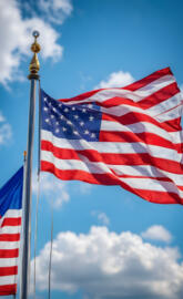 USA Flag flying on a Pole with blue sky