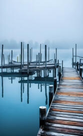 a dock with a row of wooden posts in the water