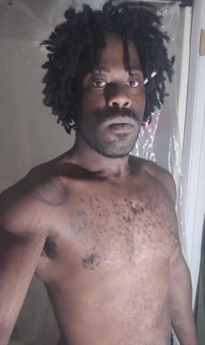 Black man with clean cut facial hair short dreads dress as Goku