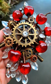a hand holding a gold and silver watch with red balls